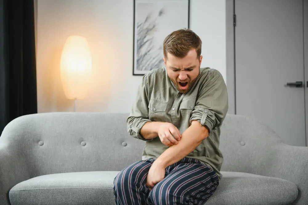 man scratching in couch