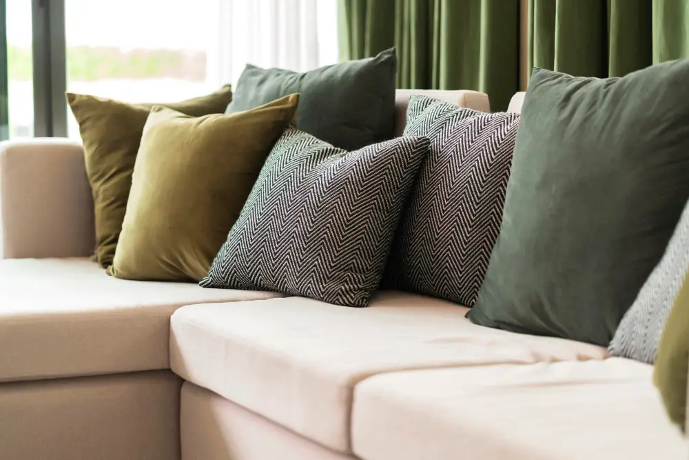 beige couch with green curtain