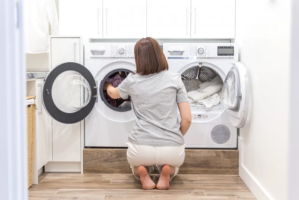 woman putting fabrics in washing machine