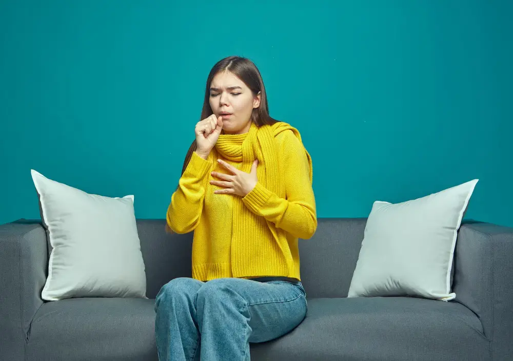 A woman coughing near on couch inhaling fiberglass 