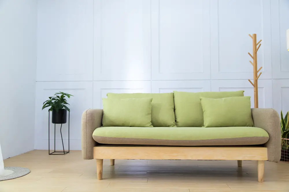 apple green grey couch with pillows white wall