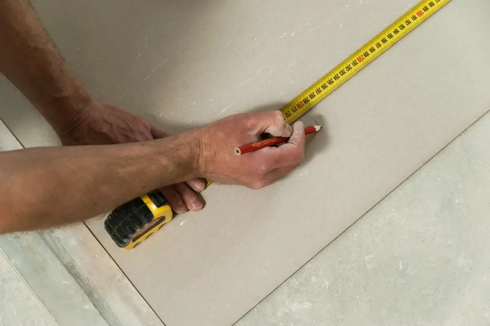 Measure Drywall with Measuring Tape and Pencil